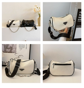 Detail of minimalist crossbody bag featuring wide logo strap and silver chain strap