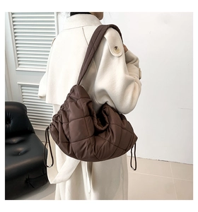 Detail der braunen Stepptasche mit seitlichem Kordelzug und breitem Polsterriemen