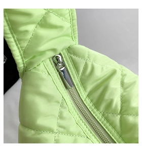 Detalle del bolso tote acolchado verde neón con cremallera metálica plateada y costuras