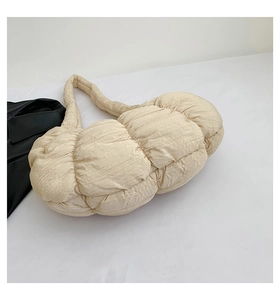 Detail of cream pleated cloud bag with soft bubble texture and wide shoulder strap