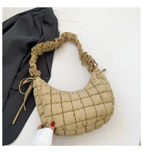 Detail of khaki quilted dumpling bag with ruffled shoulder strap and side drawstring knot