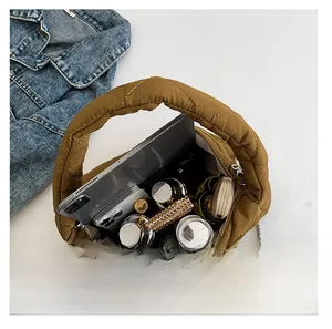 Vue de la capacité du sac matelassé marron avec espace pour téléphone et maquillage