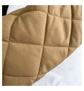 Gros plan sur la texture à motif de losanges matelassés du sac à bandoulière kaki