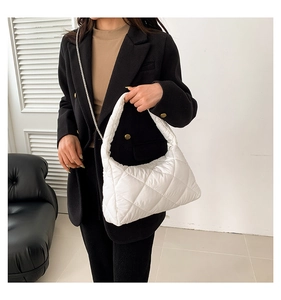 Détail du sac matelassé blanc avec surpiqûres en losanges et bandoulière chaîne argent