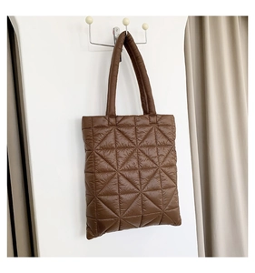 Close-up of brown quilted tote bag with triangle padding and soft puffer nylon texture
