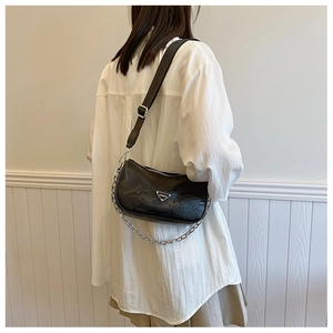 Detail of black pleated pillow bag with silver chain and wide adjustable strap