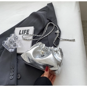 Detail of silver pleated cloud bag with pearl charms and metal chain strap