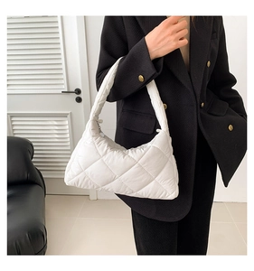 Gros plan sur le sac à bandoulière matelassé blanc avec une silhouette triangle épurée