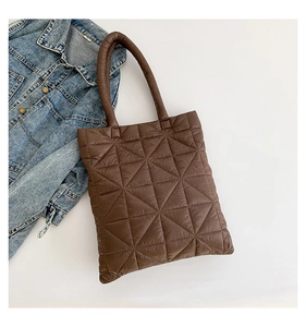Detail shot of brown quilted tote bag with geometric stitching and soft texture