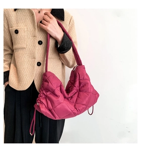 Detail der fuchsiafarbenen Stepptasche mit Kordelzug und silbernen Reißverschlüssen