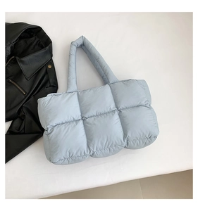 Detailansicht der hellblauen Stepp-Puffertasche mit weicher Wattierung und Gurt