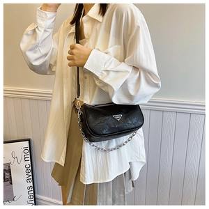Detail of black pleated shoulder bag with silver triangle logo and metal chain strap