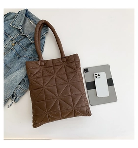Brown quilted tote bag showing large capacity for tablet and phone in a flat lay setup