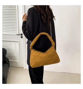 Détail du sac matelassé jaune moutarde avec surpiqûres en losanges et bandoulière