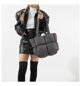 Close-up of grey quilted puffer tote bag with soft padded texture and minimalist design