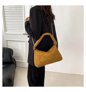 Vue détaillée du sac matelassé jaune gingembre avec texture douce et bandoulière