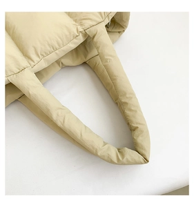 Makrodetail der beigen gesteppten Nylon-Handtasche mit weicher Daunentextur und Nähten