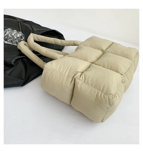 Detail der gesteppten Tragetasche in Beige mit dicken Schultergurten und weichem Stoff