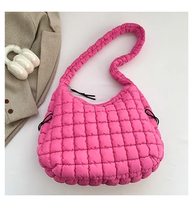 Detail of pink quilted puffer shoulder bag featuring cloud-like texture and black drawstrings