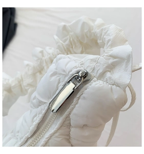 Detail of silver metal zipper and soft padded white fabric on chic crossbody bag