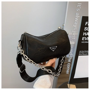 Detail shot of black wrinkled texture crossbody bag with silver chain and wide strap