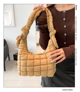 Detalle del bolso acolchado camel con correa anudada y cierre de cremallera dorada