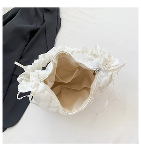 Internal view of the white quilted dumpling bag showing pockets and soft fabric lining