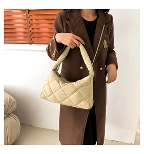 Détail du sac à bandoulière matelassé beige avec chaîne et texture douce rembourrée
