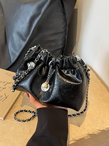 Fashionable black pleated bucket bag with silver chain and pearl charm detail