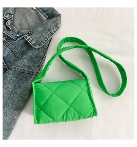 Gedetailleerde weergave van de felgroene gewatteerde crossbodytas op een spijkerjas