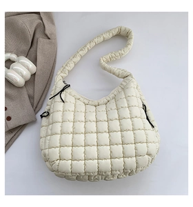 Flat lay of cream quilted bubble shoulder bag with soft padded texture and minimalist decor