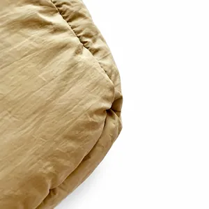 Close-up of quilted light khaki puffy fabric with soft nylon texture and detail view