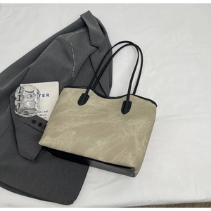 Minimalist large tote bag in khaki and black trim displayed with modern urban accessories