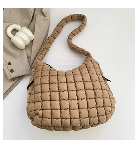 Top view of a khaki quilted puffy bag with square stitching and adjustable drawstring side