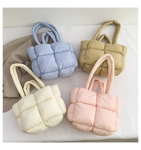 Close-up of quilted down puffer tote bags in pastel blue, khaki, cream and light pink colors