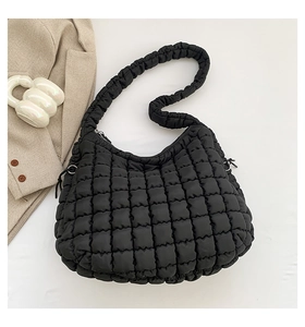 Detailed top view of black quilted puff shoulder bag with textured bubble fabric design