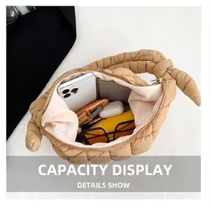 Vista interior del bolso acolchado beige mostrando capacidad para móvil y accesorios