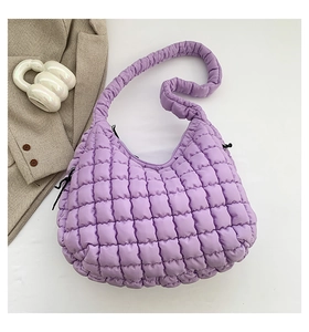 Detail of purple quilted puff shoulder bag with textured square stitching and black drawstrings