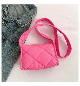 Detail van de felroze gewatteerde bubble crossbody tas op een spijkerjasje