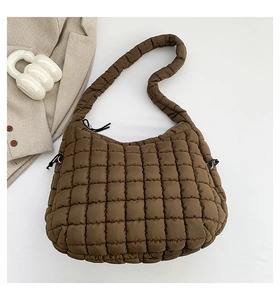 Flat lay of a large coffee brown quilted bubble bag next to a blazer and a cup