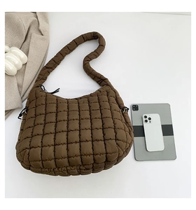 Top view of spacious brown quilted puffy bag showing storage capacity for tablets