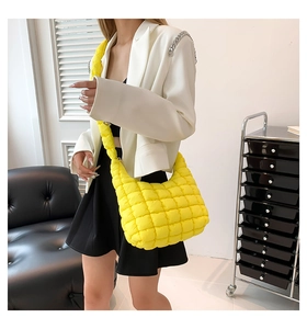 Detalle de un bolso bandolera acolchado amarillo brillante con silueta de hobo