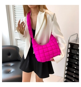 Detalle del bolso acolchado rosa con textura de nailon suave y correa ancha acolchada