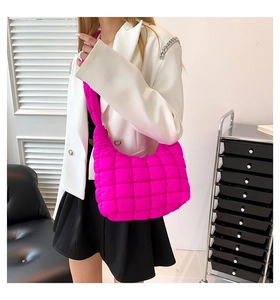 Detalle de bolso bandolera de nailon acolchado rosa con blazer blanco y falda negra