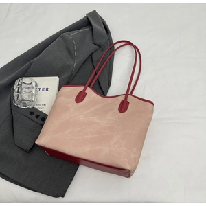 Detail of pink frosted tote bag with contrasting burgundy leather handles and trim