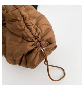 Detailaufnahme der braunen Stepptasche mit Kordelzug und silbernem Metallverschluss