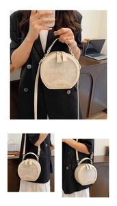 Detail of round cream handbag with floral embroidery and adjustable strap in use