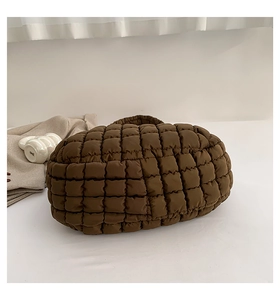 Detail of coffee brown quilted puffer tote bag with soft square padded texture and handles