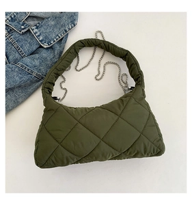 Détail d'un sac à bandoulière en nylon matelassé vert armée avec chaîne argentée chic