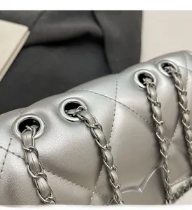 Detailed macro view of silver quilted leather bag showing metal eyelets and chain strap